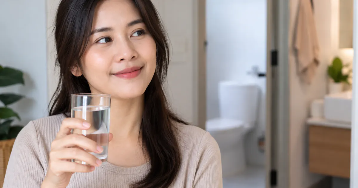 Người phụ nữ uống nước và duy trì thói quen chăm sóc đường tiết niệu