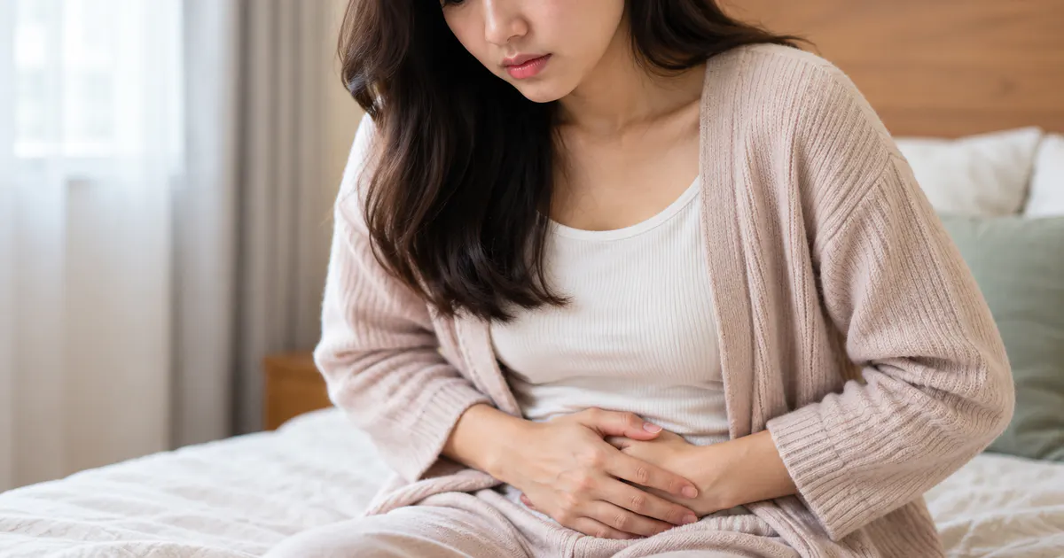 Phụ nữ ôm nhẹ vùng bụng dưới khi chảy máu sau quan hệ kèm đau